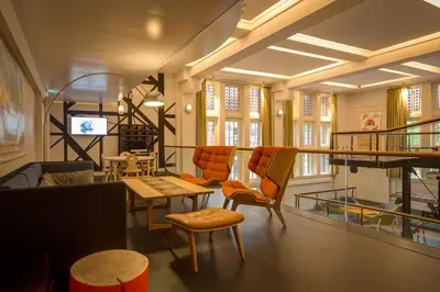 a living room with orange chairs and a table at Generator Amsterdam in Amsterdam