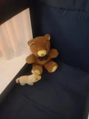 a teddy bear and a smaller teddy bear sitting on a bed at Studio53Amsterdam in Amsterdam
