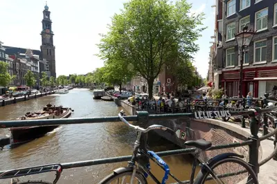 a bike parked on a railing next to a canal at Studio53Amsterdam in Amsterdam