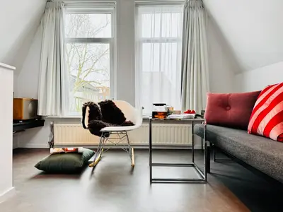 a living room with a chair and a couch at Betty Blue Bed & Breakfast in Gouda