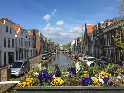 a canal in the middle of a city with flowers at Betty Blue Bed & Breakfast in Gouda