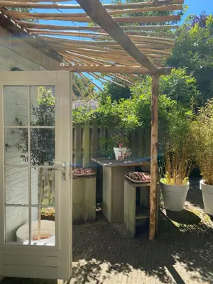 a wooden pergola with a tub in a garden at Studio Lief Bergen binnen, bij bos duin en dorp in Bergen