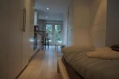 a bedroom with a bed and a hallway with a table at Studio Lief Bergen binnen, bij bos duin en dorp in Bergen