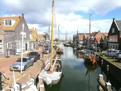 a group of boats docked in a canal in a city at The Dutch Buoy in Monnickendam