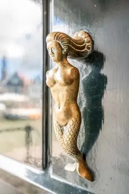 a figurine of a mermaid on a glass door at The Dutch Buoy in Monnickendam