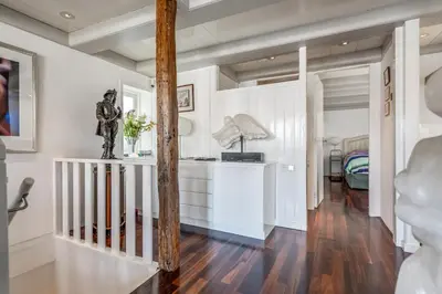 a hallway with white walls and a staircase with a statue at The Dutch Buoy in Monnickendam