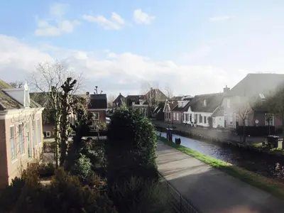 a view of a town with a river and houses at House of Cocagne in Kockengen