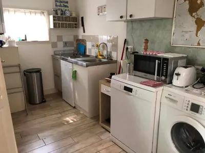 a kitchen with a sink and a washing machine at Cozy Cottage in Utrecht