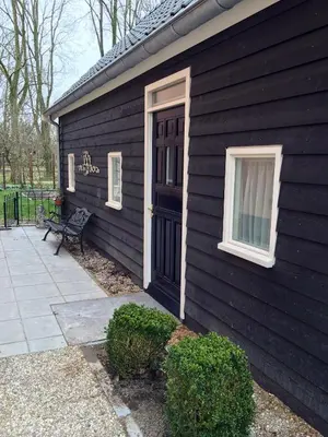 a black house with a black door and a bench at Cozy Cottage in Utrecht