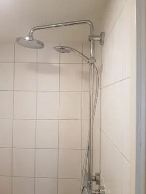 a shower with two lights on a white tiled wall at Cozy Cottage in Utrecht