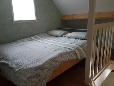 a bed in a bedroom with a stair case at Cozy Cottage in Utrecht