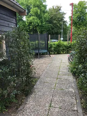a garden with a bench and a fence at Cozy Cottage in Utrecht