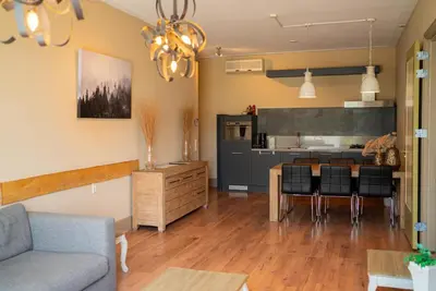 a living room with a couch and a kitchen at Hotel Beemster in Middenbeemster