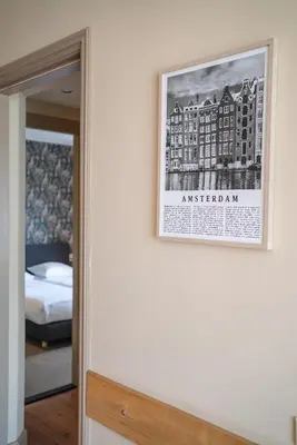 a picture hanging on a wall next to a bedroom at Hotel Beemster in Middenbeemster