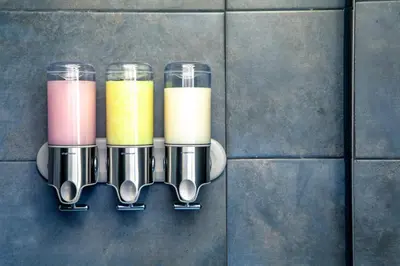a row of different colored drinks in glass cups on a wall at Zwanestein Canal House in Amsterdam