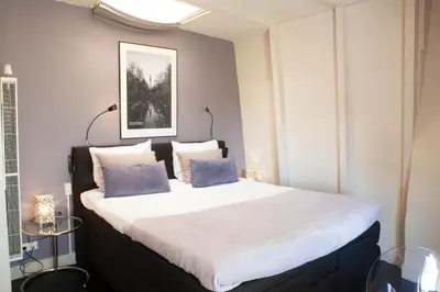 a bedroom with a large bed with two pillows at Zwanestein Canal House in Amsterdam