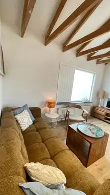 a living room with a brown couch and a table at Kust 1 in Egmond aan Zee