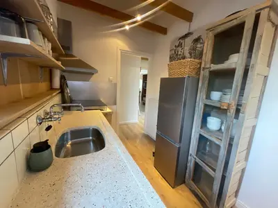 a kitchen with a sink and a refrigerator at Kust 1 in Egmond aan Zee