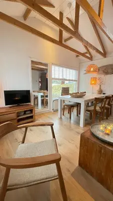 a living room with a table and a dining room at Kust 1 in Egmond aan Zee