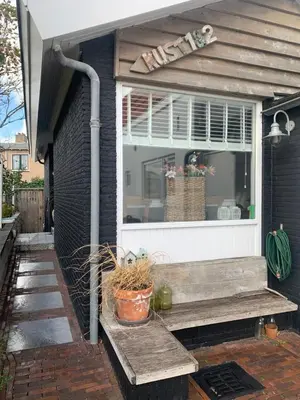 a house with a bench in front of a window at Kust 1 in Egmond aan Zee