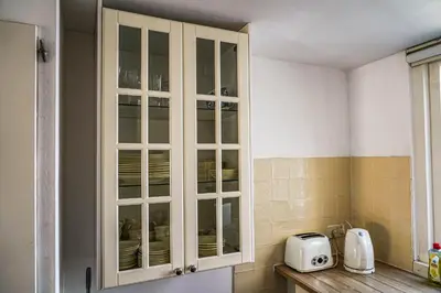 a kitchen with a glass cabinet with dishes in it at The Balcony at Prinsen Canal apartment Amsterdam in Amsterdam