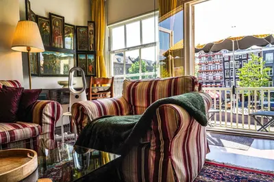 a living room with two chairs and a window at The Balcony at Prinsen Canal apartment Amsterdam in Amsterdam