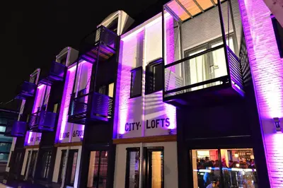 a building with purple lights on the side of it at JOINN! City Lofts Houten Utrecht in Houten
