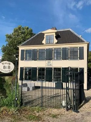 a white house with a fence in front of it at The Riverside Logies & Restaurant in Maarssen
