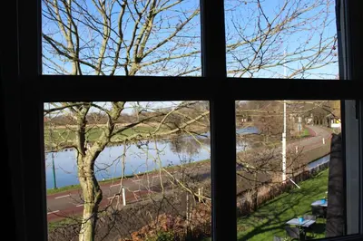 a window with a view of a river seen through it at The Riverside Logies & Restaurant in Maarssen