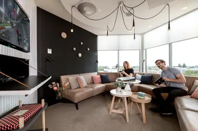 a man and a woman sitting in a living room at Zoku Amsterdam in Amsterdam