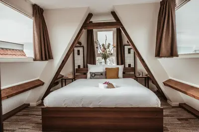 a bedroom with a white bed with a window at Mr. Jordaan in Amsterdam