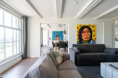 a living room with a couch and a painting on the wall at Amsterdam Centre Harbour Apartments in Amsterdam