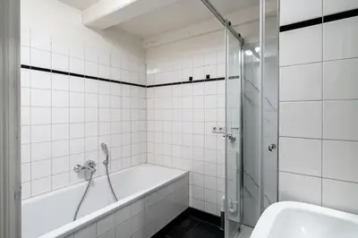a white tiled bathroom with a tub and a sink at Amsterdam Centre Harbour Apartments in Amsterdam