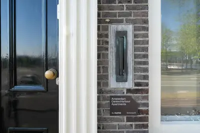 a door with a sign next to a brick wall at Amsterdam Centre Harbour Apartments in Amsterdam