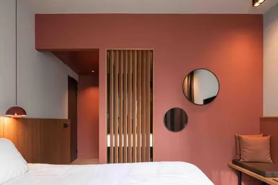 a bedroom with a bed and a mirror on a wall at Hotel & Wellness Zuiver in Amsterdam