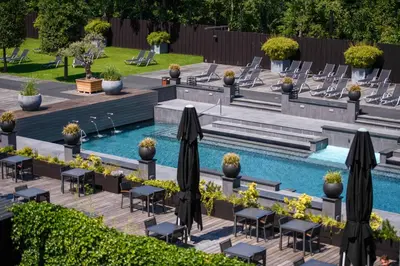 a swimming pool with tables and chairs next to a pool at Hotel & Wellness Zuiver in Amsterdam
