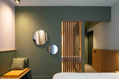 a bedroom with a bed and mirrors on the wall at Hotel & Wellness Zuiver in Amsterdam