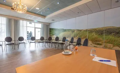 a conference room with a long table and chairs at Fletcher Hotel Restaurant De Witte Raaf in Noordwijk
