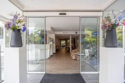 a glass door with two vases filled with flowers at Fletcher Hotel Restaurant De Witte Raaf in Noordwijk