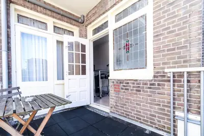 a patio with a wooden bench next to a brick wall at B&B La Festa in Amsterdam
