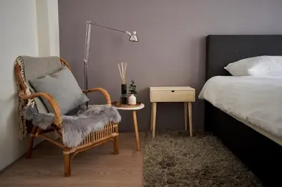 a bedroom with a chair and a bed and a lamp at B&B La Festa in Amsterdam