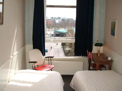 a hotel room with two beds and a window at Hotel Museumzicht in Amsterdam