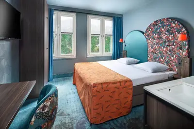 a hotel room with a bed and a sink at Hotel Babylon Heerhugowaard - Alkmaar in Heerhugowaard