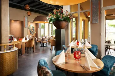 a dining room with tables and chairs and a restaurant at Hotel Babylon Heerhugowaard - Alkmaar in Heerhugowaard