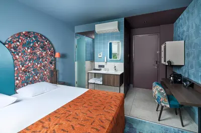 a hotel room with a bed and a sink at Hotel Babylon Heerhugowaard - Alkmaar in Heerhugowaard
