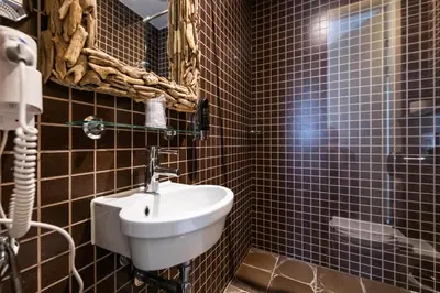 a bathroom with a white sink and blue tiled walls at Acostar Hotel in Amsterdam