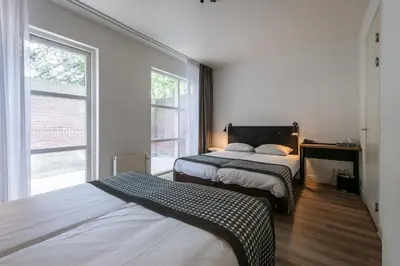 a bedroom with two beds and a window at Acostar Hotel in Amsterdam