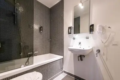 a bathroom with a sink and a toilet and a tub at Acostar Hotel in Amsterdam