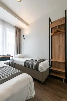 a hotel room with two beds and a window at Acostar Hotel in Amsterdam