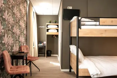 a dorm room with bunk beds and a desk at Hotel Villa Flora in Hillegom